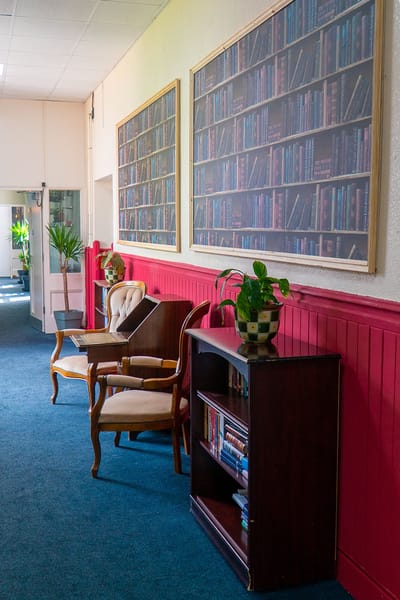 Common area with library-themed wall art and seating
