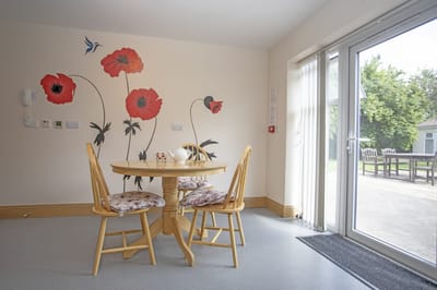 Bright common area with a round table and floral wall art