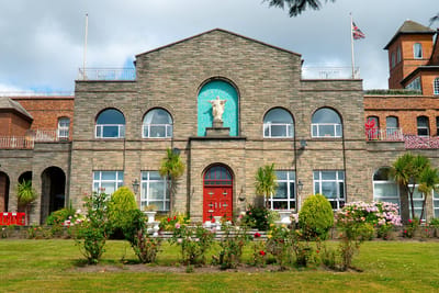Exterior view of Nazareth House Crosby with flowers and greenery