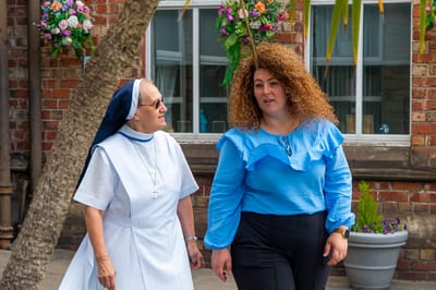 Two women walking in a garden area