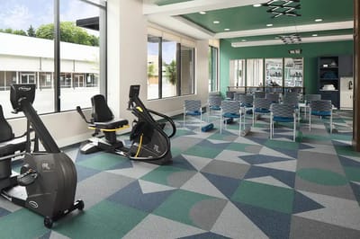 A well-equipped exercise room with fitness equipment and seating