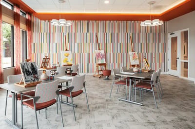 Bright activity room with art supplies and easels.