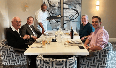 Residents enjoying a meal with staff at a dining table