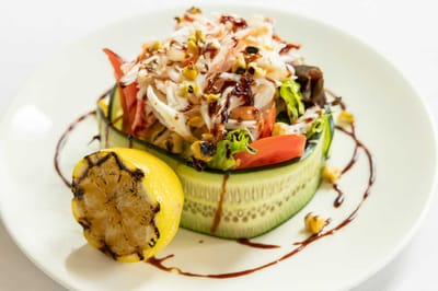 A vibrant salad garnished with grilled lemon