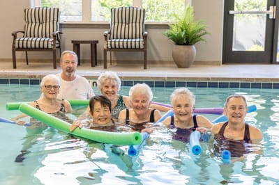 Residents enjoying a swimming activity in an indoor pool