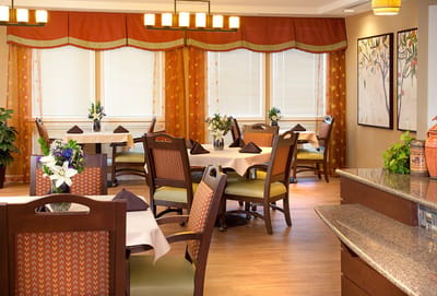 Bright dining room with tables and chairs set for meals