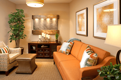 Cozy common area with orange couch and decorative artwork