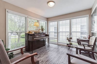 Bright common area with seating and a piano
