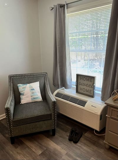Cozy resident room with a chair and decorative sign