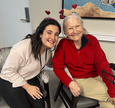 Staff member posing with a resident in a common area