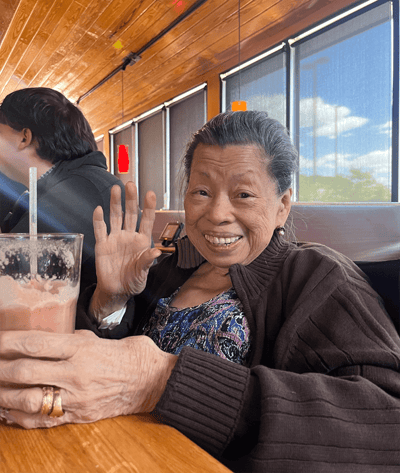 A resident enjoying a drink and smiling warmly