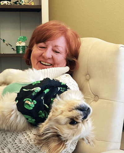 Resident enjoying time with a dog in a cozy setting