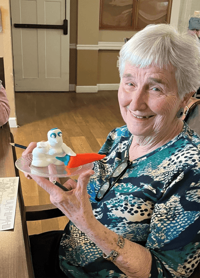A resident holding a colorful art project