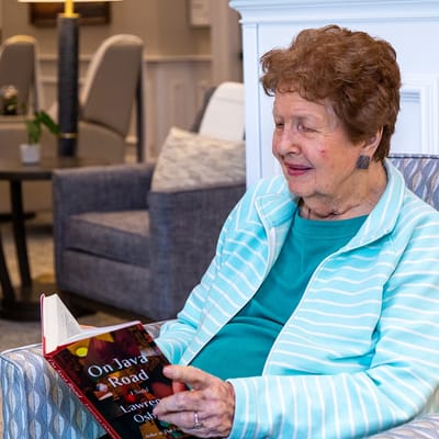 Resident reading in a cozy seating area