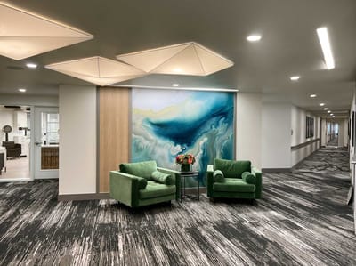 Cozy common area with green chairs and decorative wall art