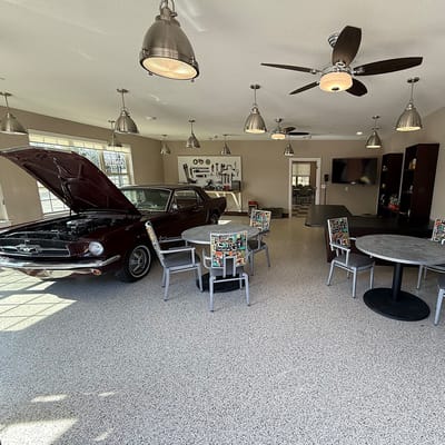 Interior view of a hobby area with a classic car and seating