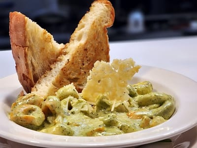 Plate of pasta with garlic toast and a garnish