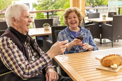 Residents enjoying wine and conversation outdoors