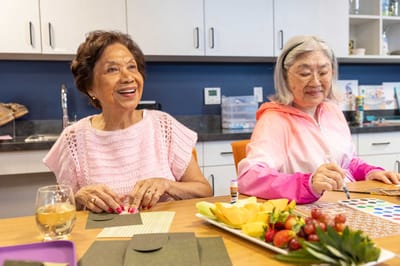 Two residents enjoying an art activity at a table