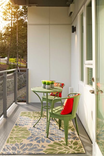 Cozy balcony with green chairs and a table