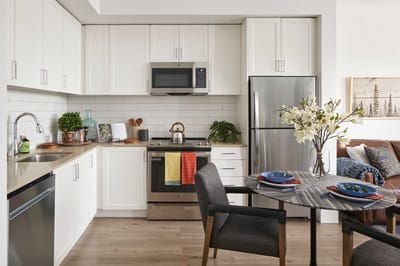 Modern kitchen with dining area in a senior living unit