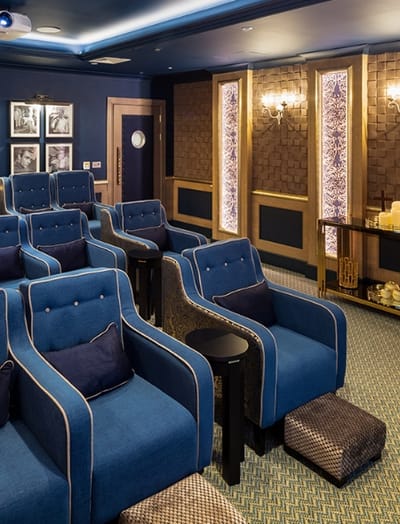Cozy theater room with blue seating and ambient lighting
