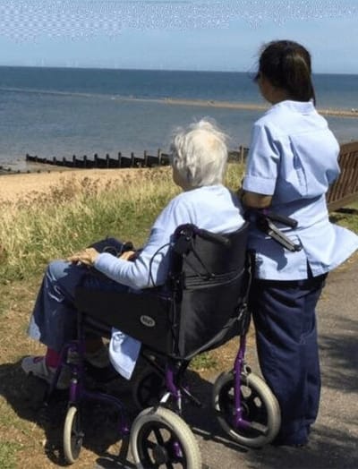 Staff member with resident by the beach