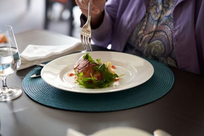 Resident enjoying a plated meal in the dining room