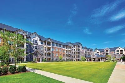 Exterior view of a senior living facility with green space