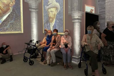 Residents enjoying an art presentation in a common area