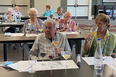 Residents participating in a wine tasting event indoors
