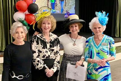 Residents participating in an event, smiling and wearing hats