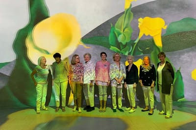 Residents posing together in an activity room with projections
