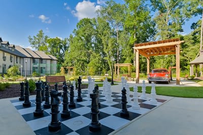 Outdoor chess set near facility with trees