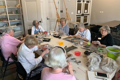 Residents engaged in an art activity at a crafting table