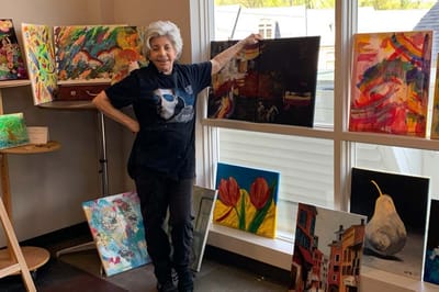 Resident showcasing art in a brightly lit room