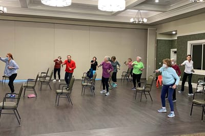 Residents participating in an exercise class in a community room