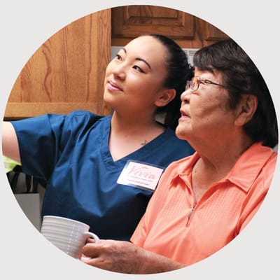 Nurse assisting a resident in a cozy interior setting