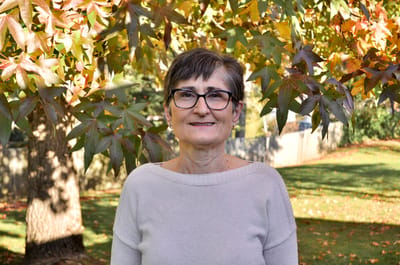 A resident smiling outdoors in a garden