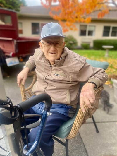 Senior smiling while sitting outdoors in a chair