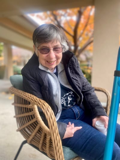 Resident enjoying a sunny day outside in a chair