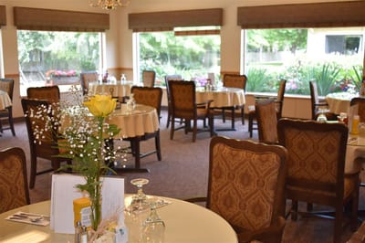 Bright dining room with tables set for residents