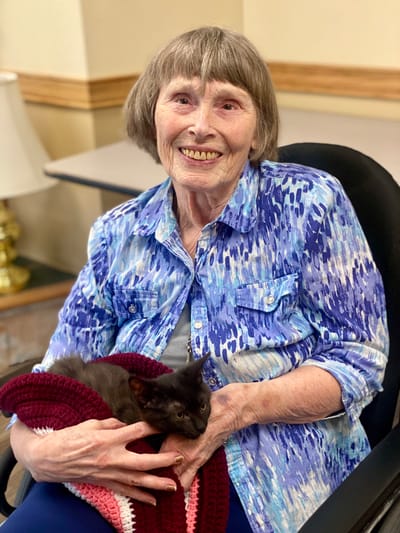 Resident holding a cat in a common area