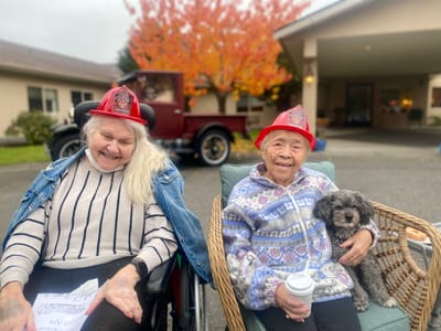 Two residents enjoying the outdoors with smiles and hats