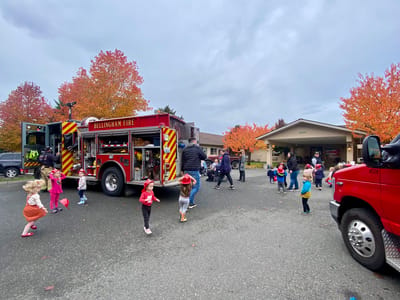 Children interacting with a fire truck outside the facility