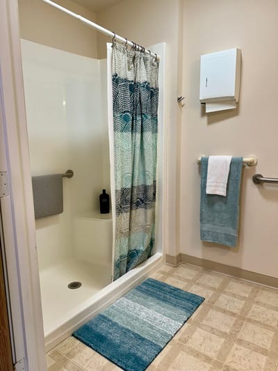 Bathroom with shower and colorful rugs