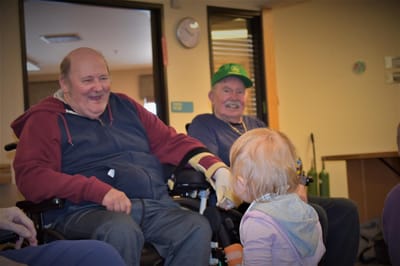 Residents smiling and interacting with a young child