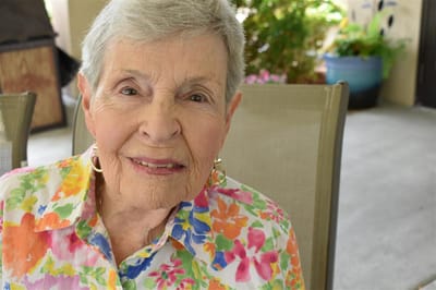 Smiling elderly woman in a colorful floral shirt