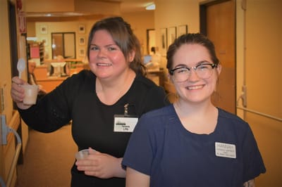 Staff members smiling in a facility hallway