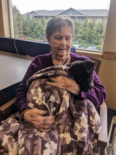 Resident holding a puppy in a cozy setting